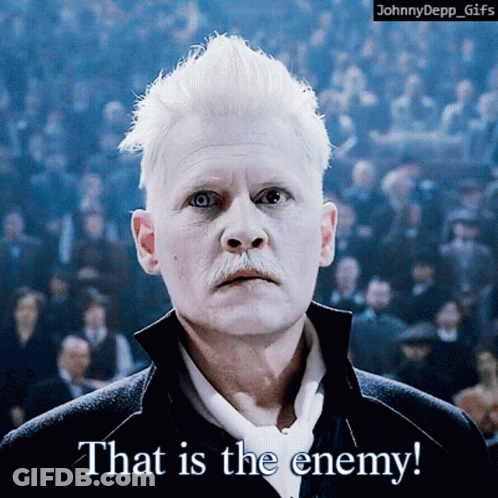 A Man With White Hair And A Mustache Says That Is The Enemy In Front Of A Crowd GIF