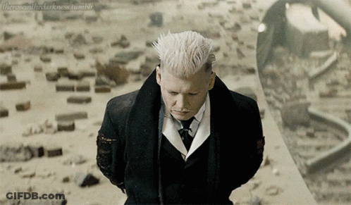 A Man With White Hair In A Suit And Tie Stands In Front Of A Mirror GIF