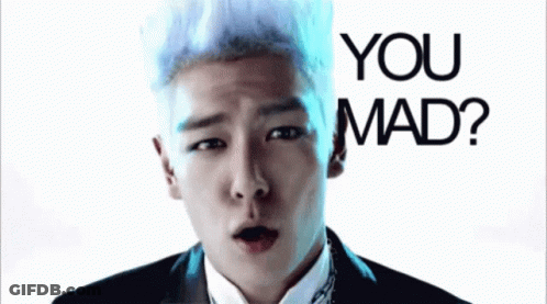 A Man With White Hair Is Making A Funny Face In Front Of A Sign That Says You Mad GIF