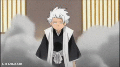 A Man With White Hair Is Standing In A Room With A Striped Wall . GIF