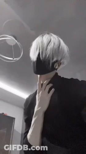 A Man With White Hair Is Wearing A Black Mask . GIF