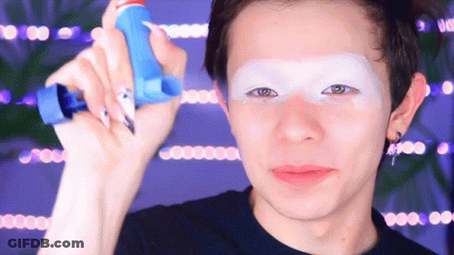 A Man With White Paint On His Face Is Holding A Blue Bottle GIF
