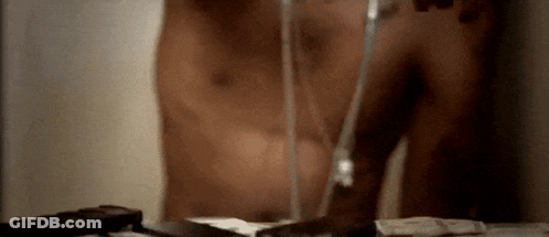 A Man Without A Shirt Is Brushing His Teeth With A Glass Of Water GIF