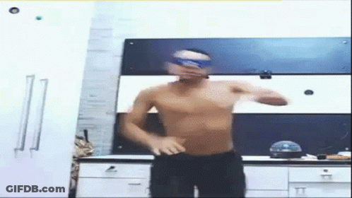 A Man Without A Shirt Is Dancing In A Kitchen Wearing Goggles . GIF