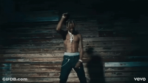 A Man Without A Shirt Is Dancing In Front Of A Wooden Wall And The Word Vevo Is On The Bottom GIF