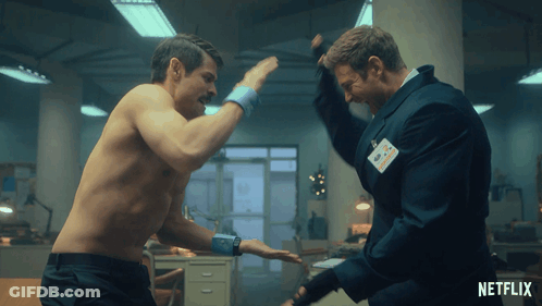 A Man Without A Shirt Is Fighting Another Man With A Name Tag That Says Netflix On It GIF
