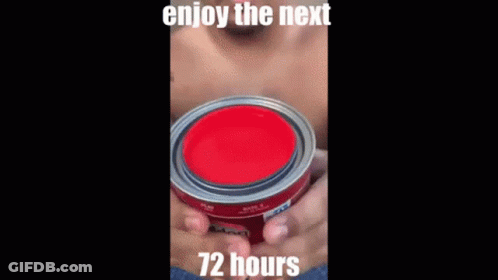 A Man Without A Shirt Is Holding A Black Container With A Red Liquid Coming Out Of It . GIF