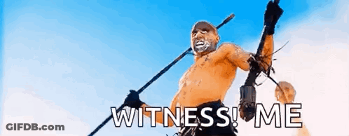 A Man Without A Shirt Is Holding A Spear And The Words `` Witness Me '' . GIF
