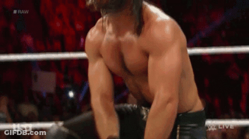 A Man Without A Shirt Is In A Wrestling Ring With A Crowd In The Background . GIF