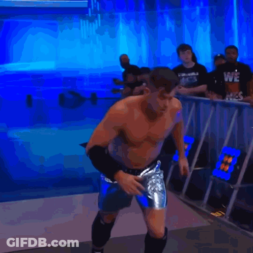 A Man Without A Shirt Is Jumping In The Air In Front Of A Blue Background GIF