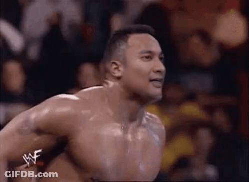 A Man Without A Shirt Is Jumping In The Air While Wearing A Wrestler 'S Belt . GIF