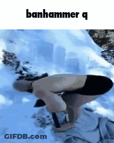 A Man Without A Shirt Is Kneeling Down In The Snow With A Hammer . GIF