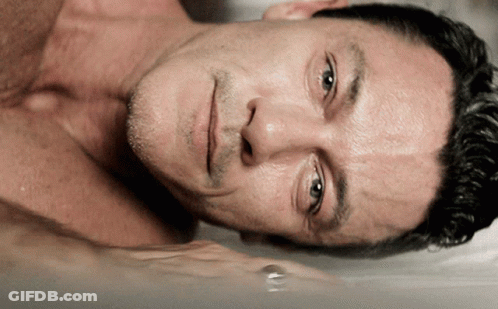 A Man Without A Shirt Is Laying In A Bathtub With His Eyes Closed GIF