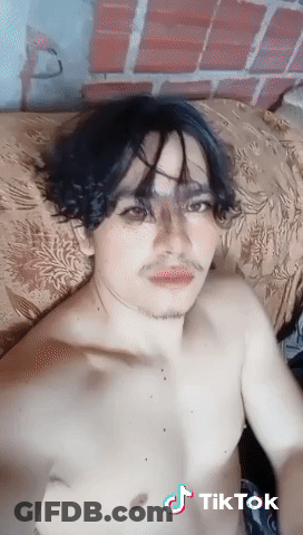A Man Without A Shirt Is Laying On A Bed With A Tiktok Watermark GIF