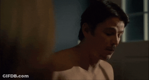 A Man Without A Shirt Is Looking At A Woman 'S Breast . GIF