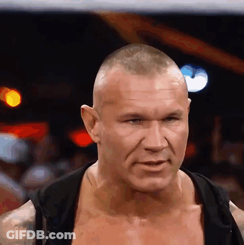 A Man Without A Shirt Is Looking At The Camera With A Serious Look On His Face GIF