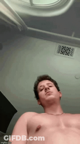A Man Without A Shirt Is Looking Up At The Ceiling GIF