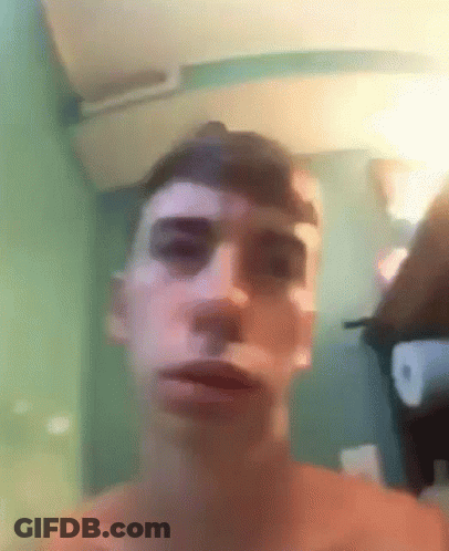 A Man Without A Shirt Is Making A Funny Face With His Mouth Open . GIF