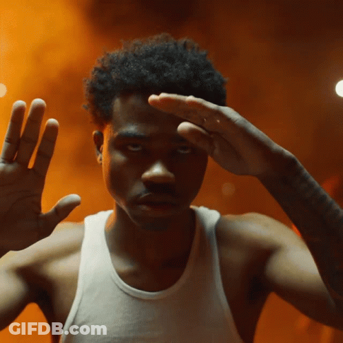 A Man Without A Shirt Is Making A Gesture With His Hands GIF