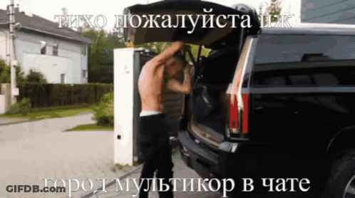 A Man Without A Shirt Is Opening The Back Of A Black Suv GIF