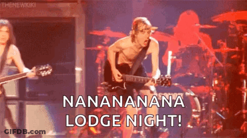 A Man Without A Shirt Is Playing A Guitar On A Stage In Front Of A Drummer . GIF