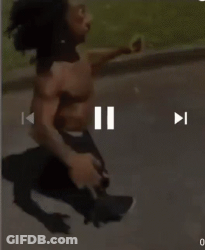 A Man Without A Shirt Is Running Down The Street GIF