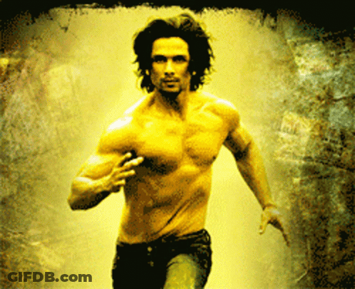 A Man Without A Shirt Is Running In A Dark Room GIF