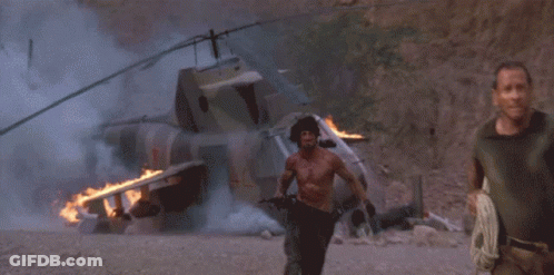 A Man Without A Shirt Is Running In Front Of A Large Explosion GIF