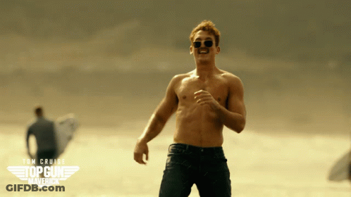 A Man Without A Shirt Is Running On A Beach With A Top Gun Maverick Logo Behind Him GIF