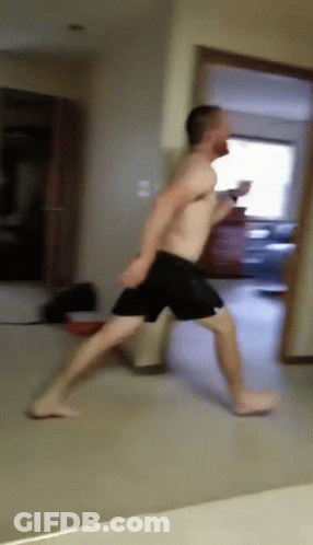 A Man Without A Shirt Is Running Through A Hallway GIF