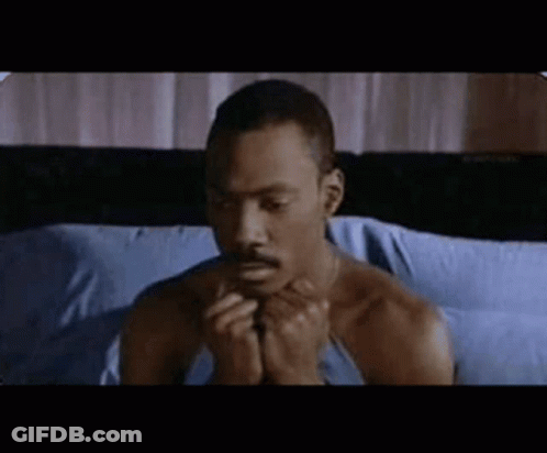 Shirtless Man Sitting On Bed With Folded Hands GIF