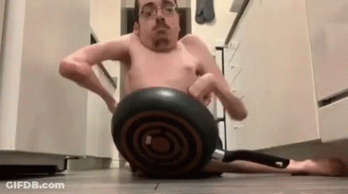 A Man Without A Shirt Is Sitting On A Pan On The Floor GIF