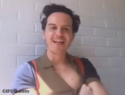 A Man Without A Shirt Is Smiling In Front Of A White Wall GIF
