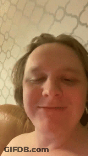 A Man Without A Shirt Is Smiling With His Eyes Closed . GIF