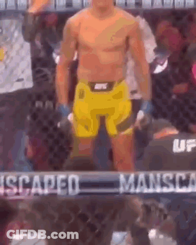 A Man Without A Shirt Is Standing In A Boxing Ring . GIF