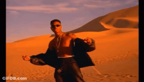 A Man Without A Shirt Is Standing In A Desert GIF