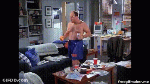 A Man Without A Shirt Is Standing In A Messy Room GIF