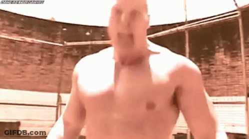 A Man Without A Shirt Is Standing In A Ring With His Mouth Open . GIF