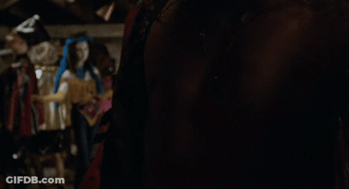 A Man Without A Shirt Is Standing In A Room GIF