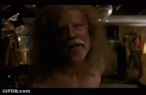 A Man Without A Shirt Is Standing In A Room GIF