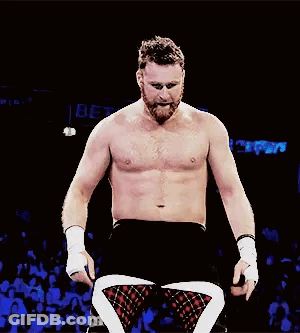 A Man Without A Shirt Is Standing In A Wrestling Ring . GIF