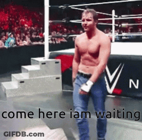 A Man Without A Shirt Is Standing In A Wrestling Ring With The Words Come Here I Am Waiting . GIF