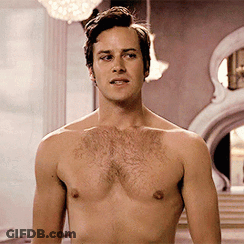 A Man Without A Shirt Is Standing In Front Of A Building GIF