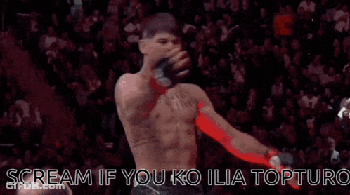 A Man Without A Shirt Is Standing In Front Of A Crowd And Screaming . GIF