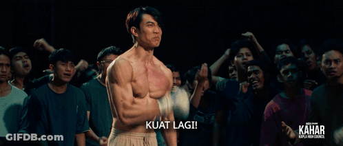A Man Without A Shirt Is Standing In Front Of A Crowd And The Caption Kuat Lagi GIF
