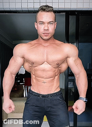 A Man Without A Shirt Is Standing In Front Of A Door With His Hands On His Hips GIF