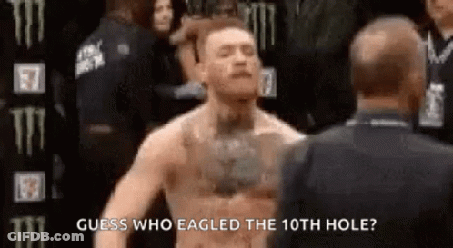 A Man Without A Shirt Is Standing In Front Of A Man In A Suit And Talking To Him . GIF