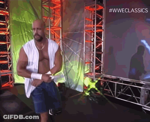 A Man Without A Shirt Is Standing In Front Of A Screen That Says #Wweclassics . GIF