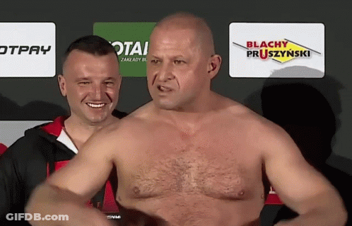 A Man Without A Shirt Is Standing In Front Of A Sign That Says Blachy Pruszzynski GIF