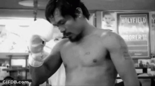 A Man Without A Shirt Is Standing In Front Of A Sign That Says Holyfield On It . GIF